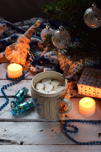 圣诞节和新年节日庆祝概念背景。可可杯配棉花糖自制巧克力饼干和花生饼干点燃的蜡烛木桌上的圣诞树装饰