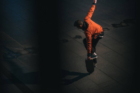 年轻滑板手板平衡的高角度视图照片