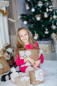 快乐的小女孩在圣诞树附近