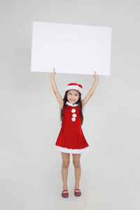 小亚洲女孩的画像在红色圣诞老人帽子藏品白色蟒蛇