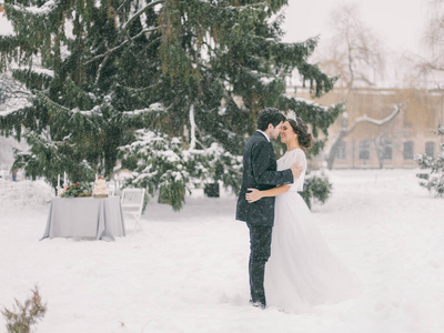 冬季婚礼。 新婚夫妇在雪地里接吻