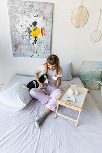 女人在床上休息时喝咖啡和小狗图片