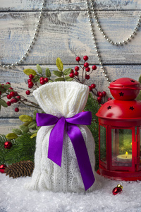 s bag with gifts on the snow and background with toys. Red candl