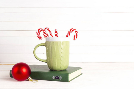 圣诞节庆祝与糖果藤和杯子在书在木头
