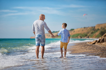 父亲和儿子在沙滩上打了一天时间。友好的家庭的概念