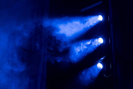 探照灯透过剧场的烟雾发出蓝光.