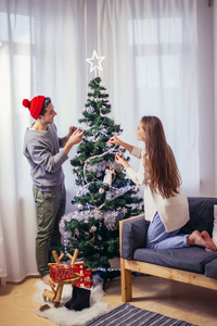 可爱, 年轻的情侣装饰一棵圣诞树