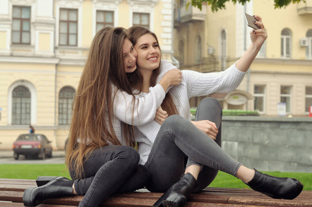 两个女朋友拥抱和笑, 因为他们做了一个自拍的照片