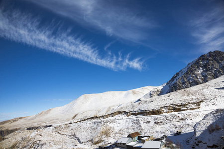 冬季景观。 美丽的山在雪白的云彩在蓝天上的风景如画的峡谷。 北高加索的普里普雷达