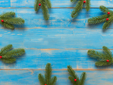 圣诞框架由冷杉枝红色浆果制成。 圣诞壁纸复制空间。 假期概念