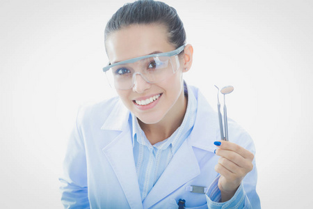 美丽的女牙医医生持有和显示孤立在白色背景上的牙刷.牙科医生照片