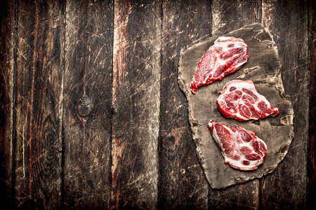 生肉背景。旧木板上的一块肉。在木背景