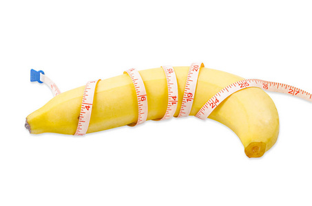新鲜的香蕉与测量磁带隔绝在白色背景