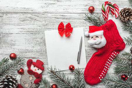 带礼物的圣诞袜子。 圣诞装饰袜子和玩具挂在灰色的乡村木制背景上。 麻布圣诞糖果的袜子，礼物蛋糕。 圣诞雪花。 顶部视图