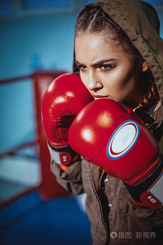 女拳击手在运动中的肖像以对抗聚光灯的战斗姿态性感健身金发女郎运动
