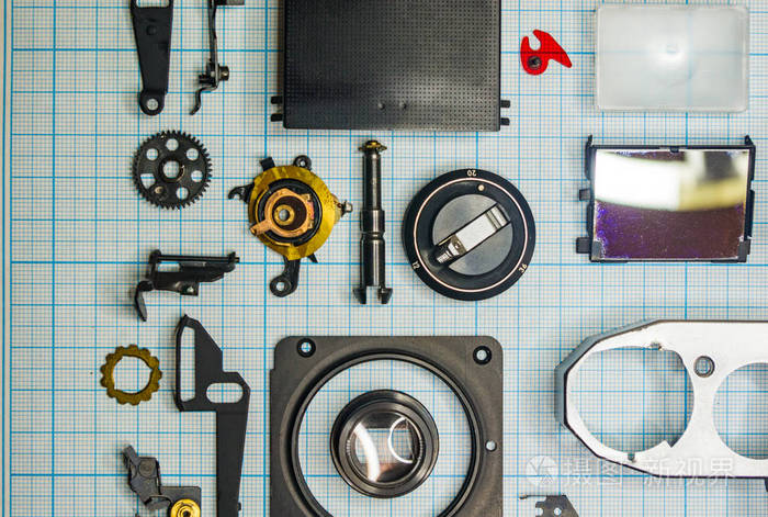 零件完全拆卸旧的复古胶片slr相机在图纸上关闭