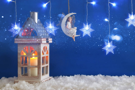 木老房子与蜡烛和仙女在月亮在雪和蓝色背景