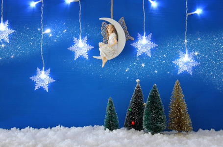 圣诞树, 雪花银色的花环, 月亮上的仙女在雪和蓝色的背景