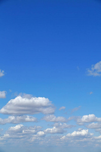 在阳光明媚的夏日，蓬松的白云映衬着蓝天。