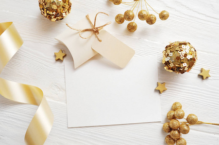 样机圣诞贺卡顶部视图和金球, flatlay 在一个白色的木质背景与丝带, 与地方为您的文本