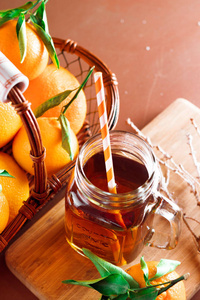 季节性和假日概念。冬天的热茶在一个木制背景的老式玻璃与柑橘。选择性焦点