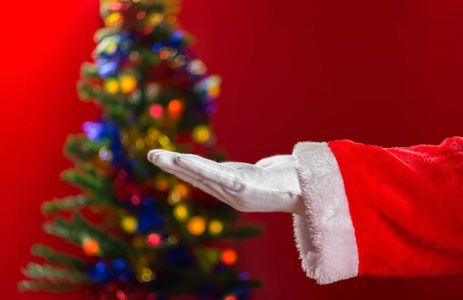 圣诞老人打开他的手，背景是装饰好的圣诞树