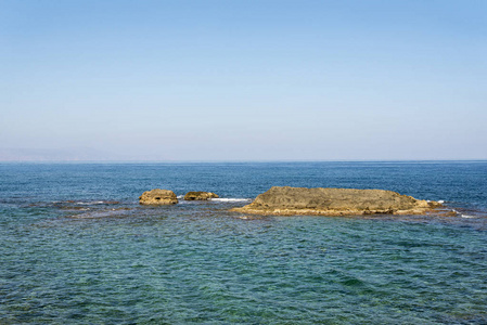 海浪在多石的海滩上，形成一朵浪花。波和溅上海滩。岩石上的海浪