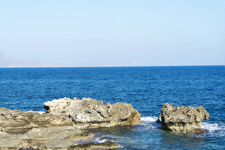 海浪在多石的海滩上，形成一朵浪花。波和溅上海滩。岩石上的海浪