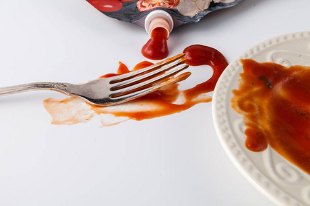 用叉子在白色背景的番茄酱污渍图片