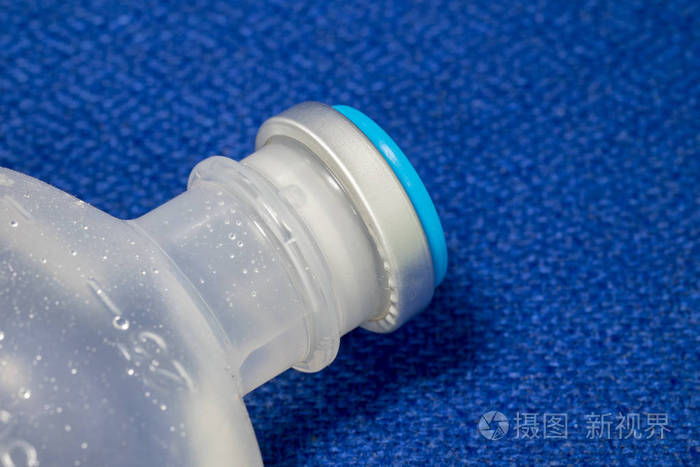溶液塑料瓶与铝拉脱帽在蓝色织物表面。