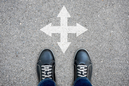 黑色休闲鞋站在十字路口. 选择东西南北四条路照片