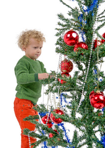 装饰圣诞树的金发小男孩