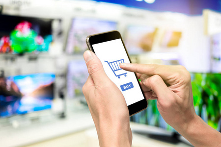 一个用智能手机进行电子商务来购买电视的人。