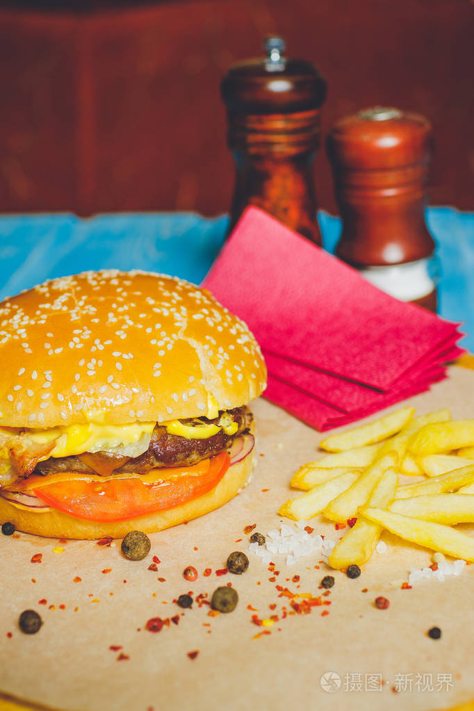新鲜牛肉汉堡加奶酪蔬菜和辣番茄酱纸蓝木底