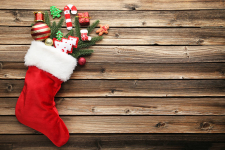 木桌上有杉树枝和圣诞装饰品的红袜