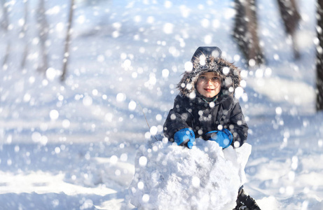 可爱男孩玩雪的冬季公园