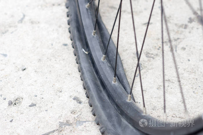 在水泥路面上有扁平轮胎的自行车车轮