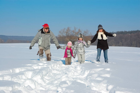 快乐的家庭在冬天散步，在假日周末在户外玩雪