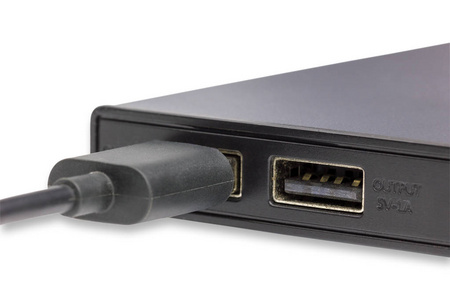 USB端口输出5伏1安培在电源库白色背景。 用于在森林或室外为移动平板电脑和相机充电。