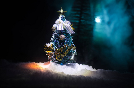 有雪冷杉树的圣诞节背景。雪盖的圣诞树在这白雪覆盖的场面的深蓝色口气明亮地站立了。色调深色背景