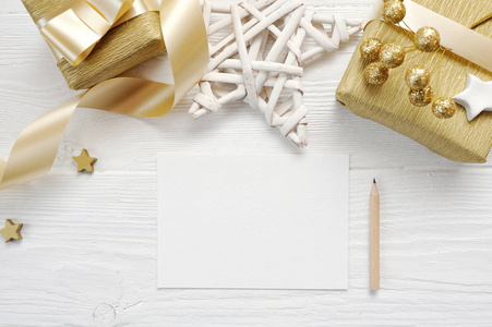 样机圣诞贺卡与黄金礼品丝带, flatlay 在一个白色的木制背景, 与地方为您的文本
