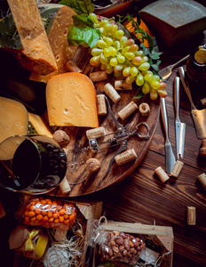 黑桌子上有奶酪和葡萄酒。