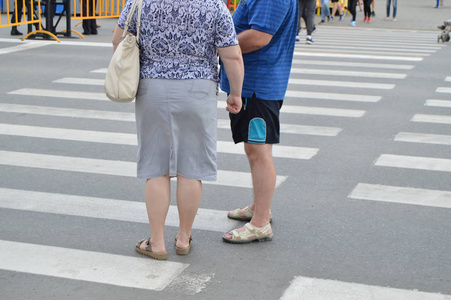 一对年长的男人和女人站在人行横道上聊天