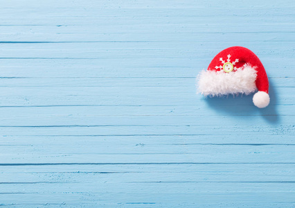 红色圣诞老人帽子在蓝色木背景