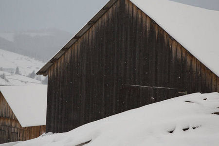 村庄的全景在冬天的山上覆盖着雪。 冬季景观。 自由和孤独的概念。