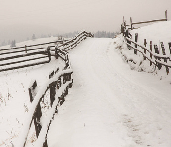 村庄的全景在冬天的山上覆盖着雪。 冬季景观。 自由和孤独的概念。