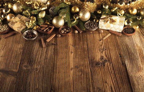 圣诞节装饰在金色和棕色的美学与礼物在盒子，金色的鲍布斯圣诞香料，所有的乡村木制背景与复制空间。