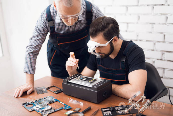 老人和年轻人一起修理手机