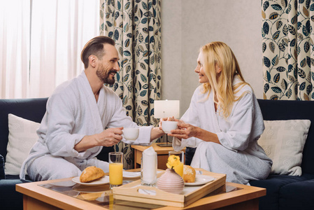 酒店客房早餐期间，一对中年夫妇在浴袍中喝咖啡