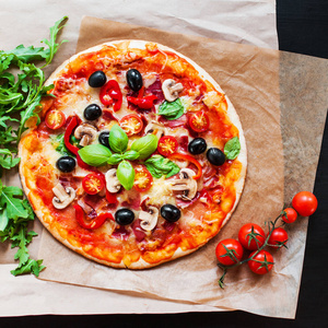 热比萨饼与意大利香肠香肠在黑暗的背景与复制空间。 比萨饼和蘑菇，西红柿，奶酪，洋葱，油，胡椒，盐，罗勒橄榄